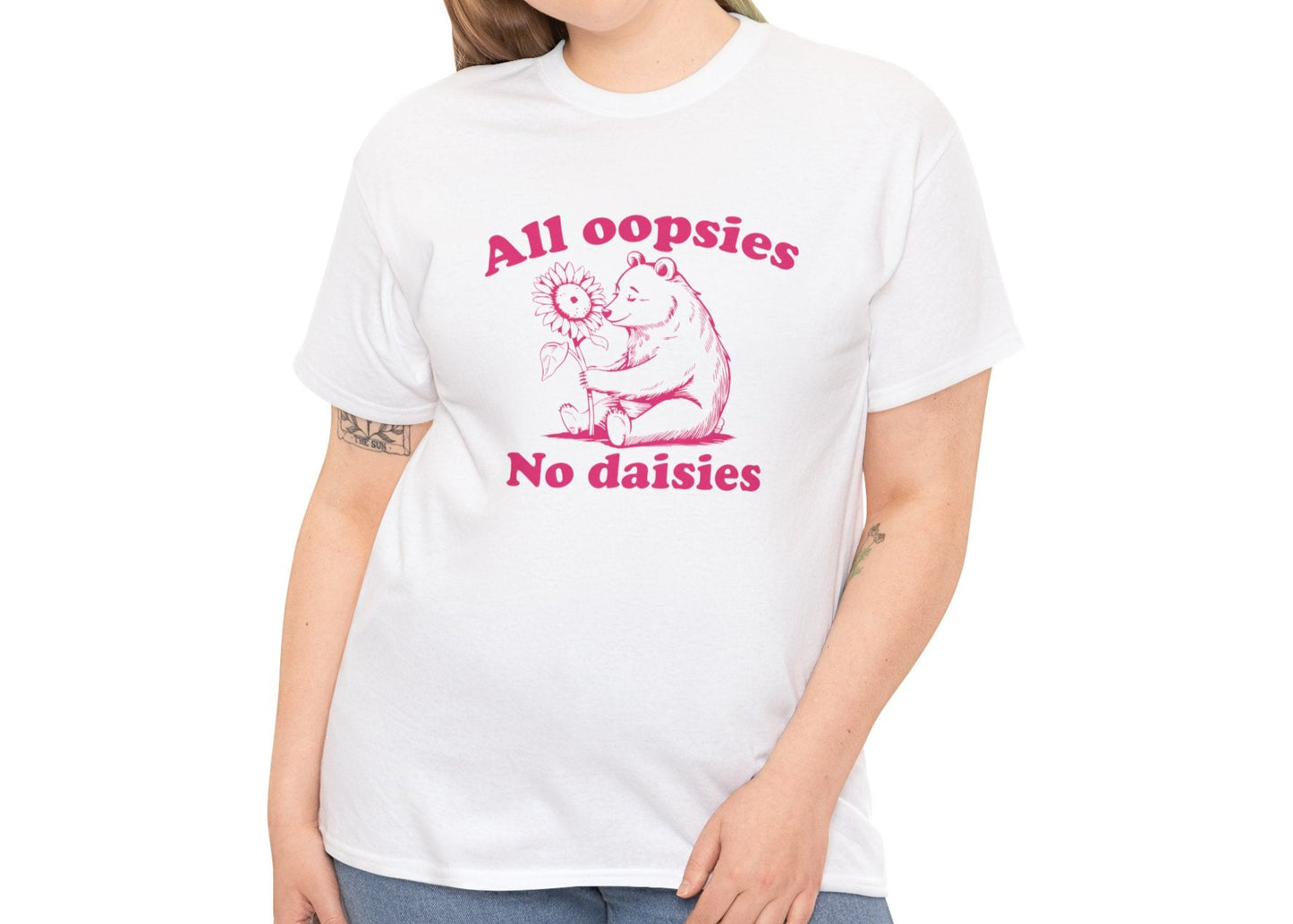 Model wearing a white T-shirt with "All oopsies, no daisies" and a playful bear graphic in pink text. Part of the Vivid Divergence Sensory Friendly Unisex Tees Range.