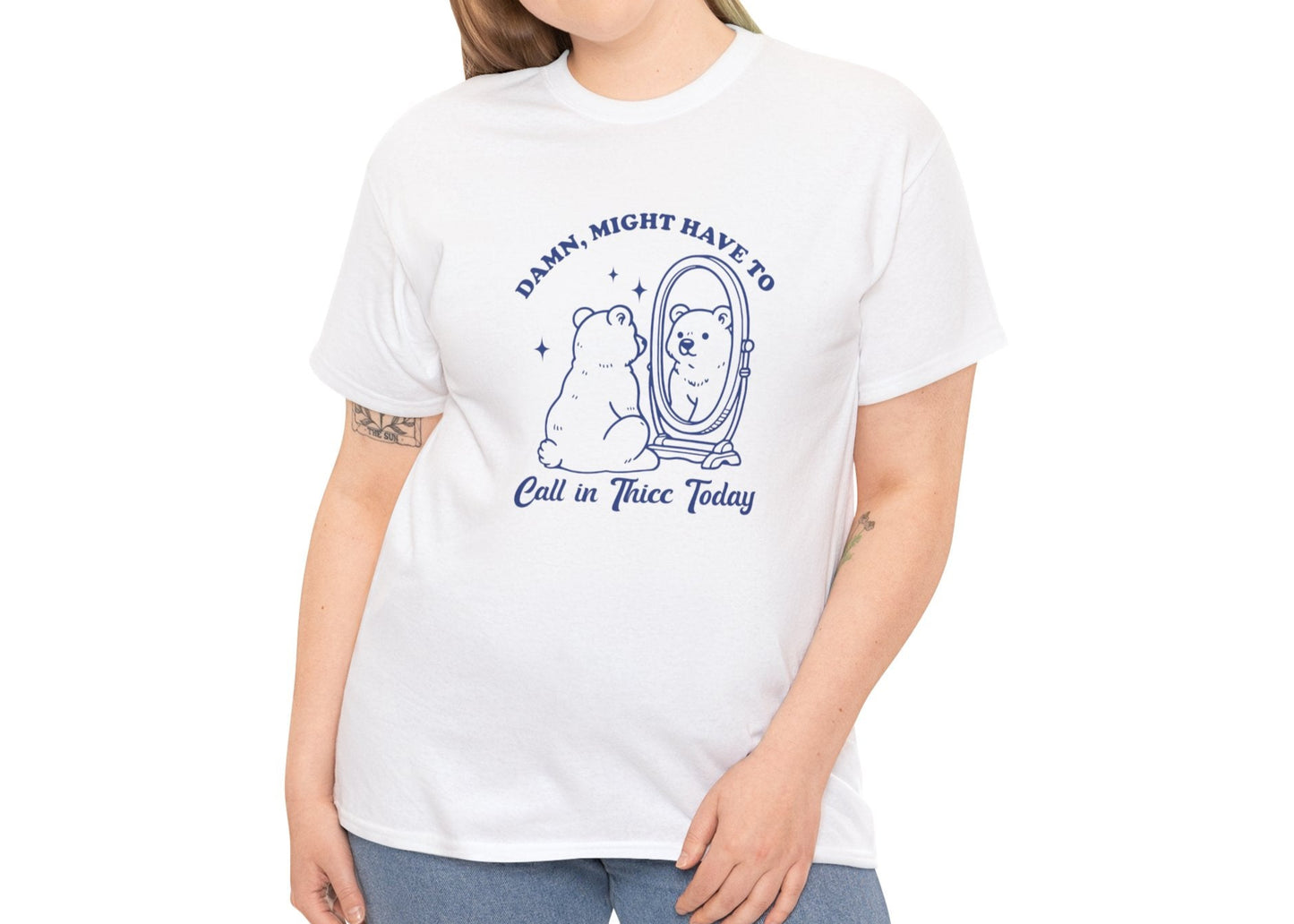 Woman wearing a white T-shirt with a sitting bear in front of a mirror and "Damn, Might Have to Calling in Thicc Today" text in blue. Part of the Vivid Divergence Sensory Friendly Unisex Tees Range.