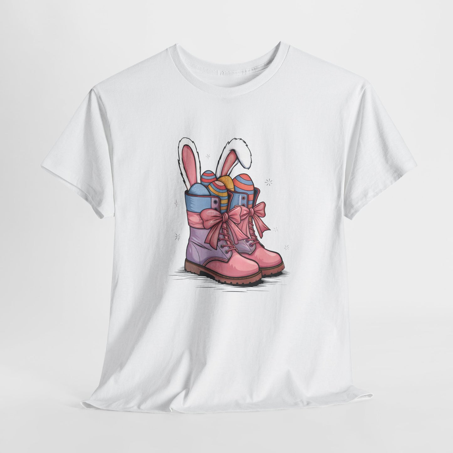 White T-shirt hanging, featuring a festive cowgirl boots design with bunny ears and pastel Easter eggs, a fun holiday tee. Hop into the season in style and shop Easter shirts online today!
