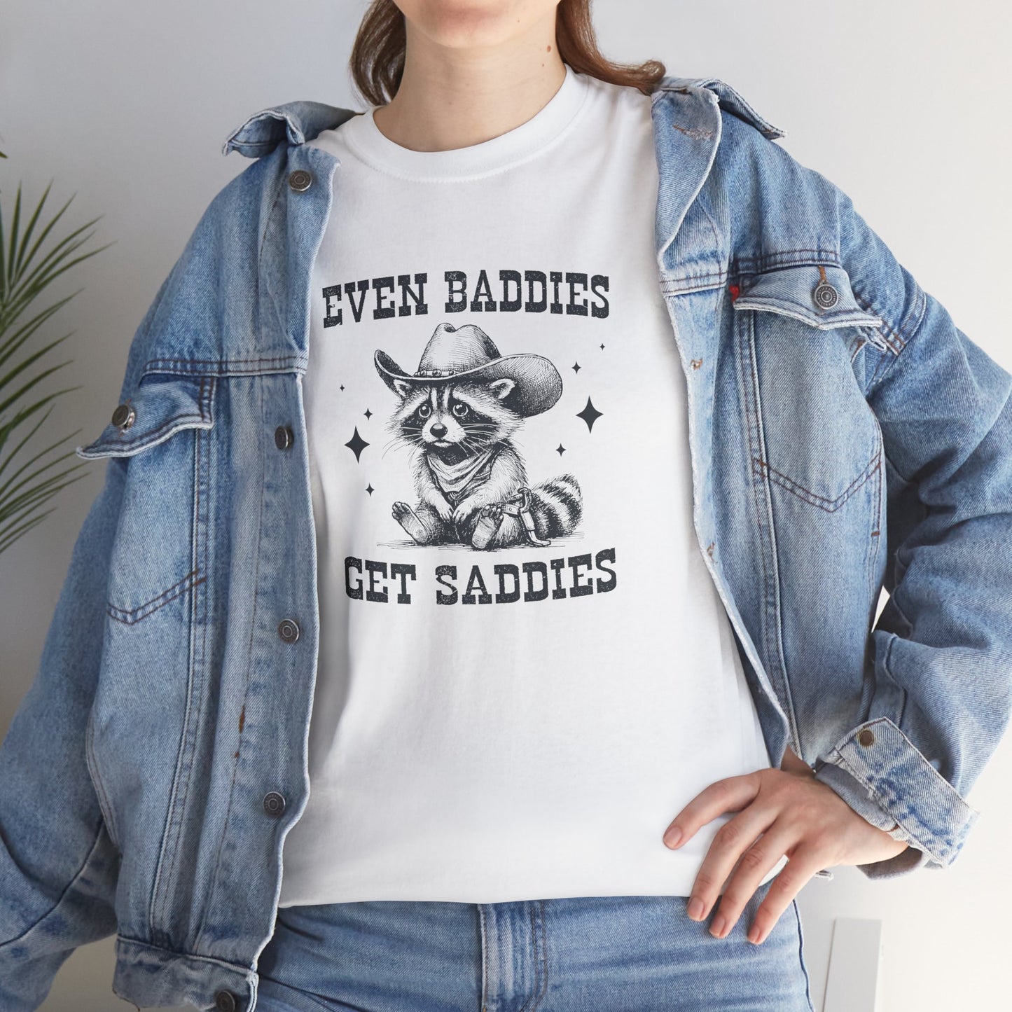 Close-up of a model wearing a white T-shirt with "Even Baddies Get Saddies" and a crying eye graphic. Part of the Vivid Divergence Sensory Friendly Unisex Tees Range.