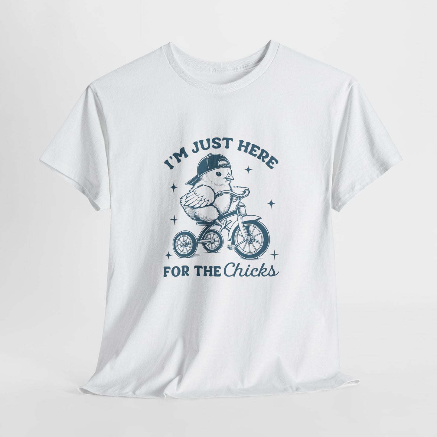 White T-shirt hanging, showcasing a playful "I'm Just Here for the Chicks" text with a chick on a bicycle, a lighthearted and festive holiday tee. Hop into the season in style and shop Easter shirts online today!