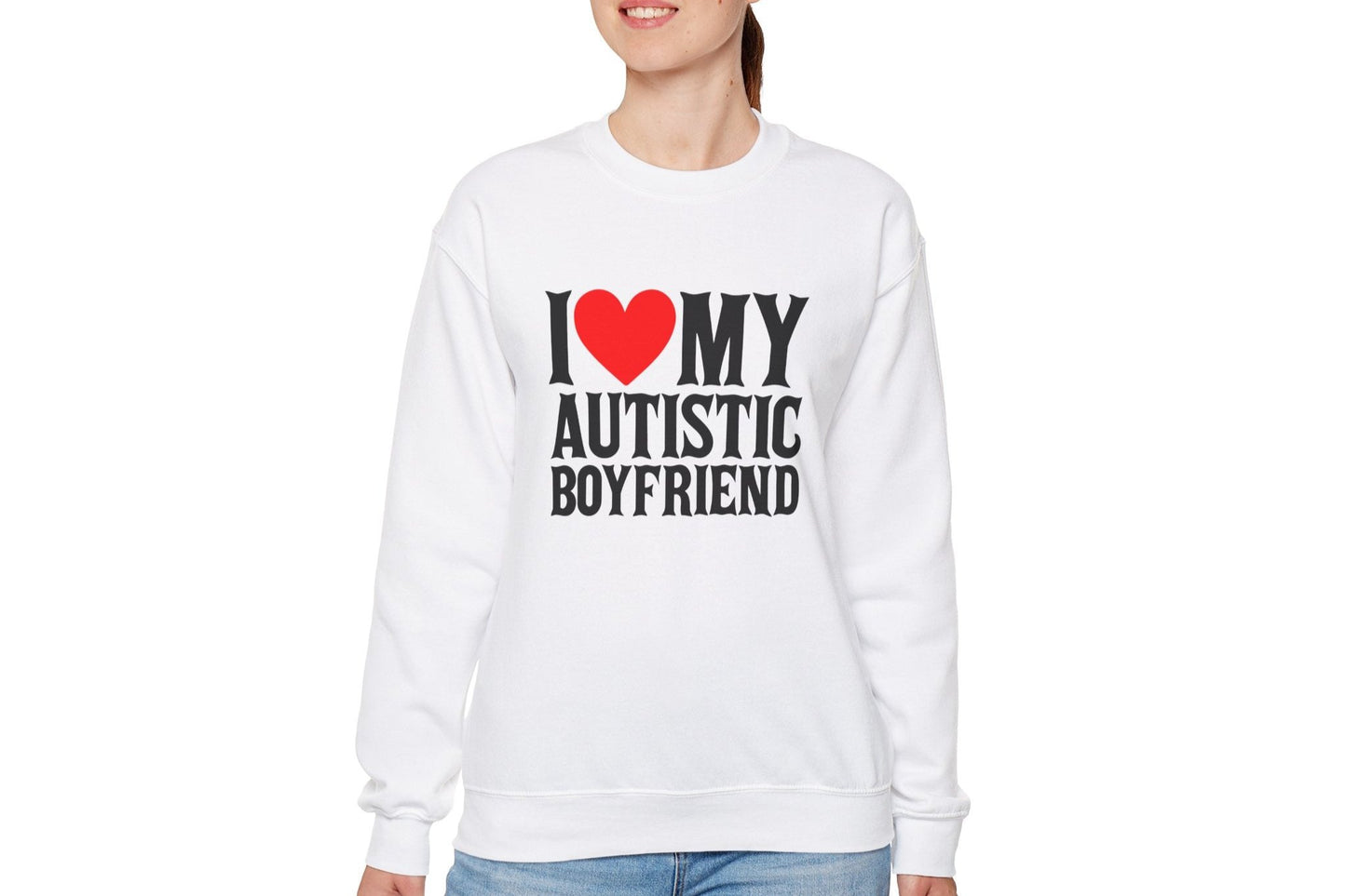 Model wearing a white sweater jumper with the text "I ❤️ My Autistic Boyfriend" in bold black and red lettering. Part of the Vivid Divergence Sensory Friendly Unisex Sweater Jumper Range.