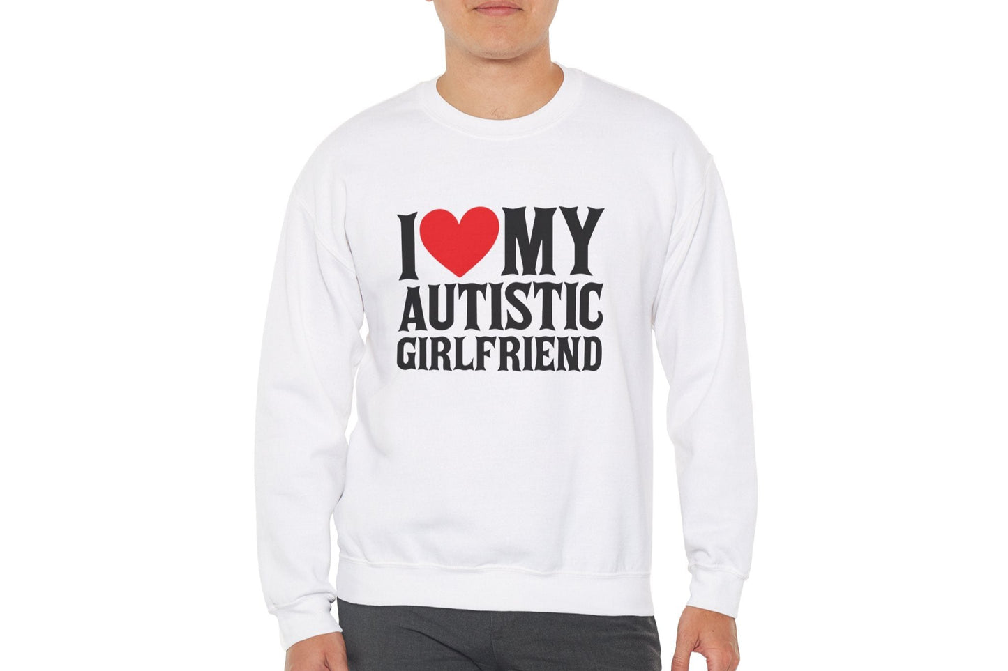 Model wearing a white sweater jumper with the text "I ❤️ My Autistic Girlfriend" in bold black and red lettering. Part of the Vivid Divergence Sensory Friendly Unisex Sweater Jumper Range.