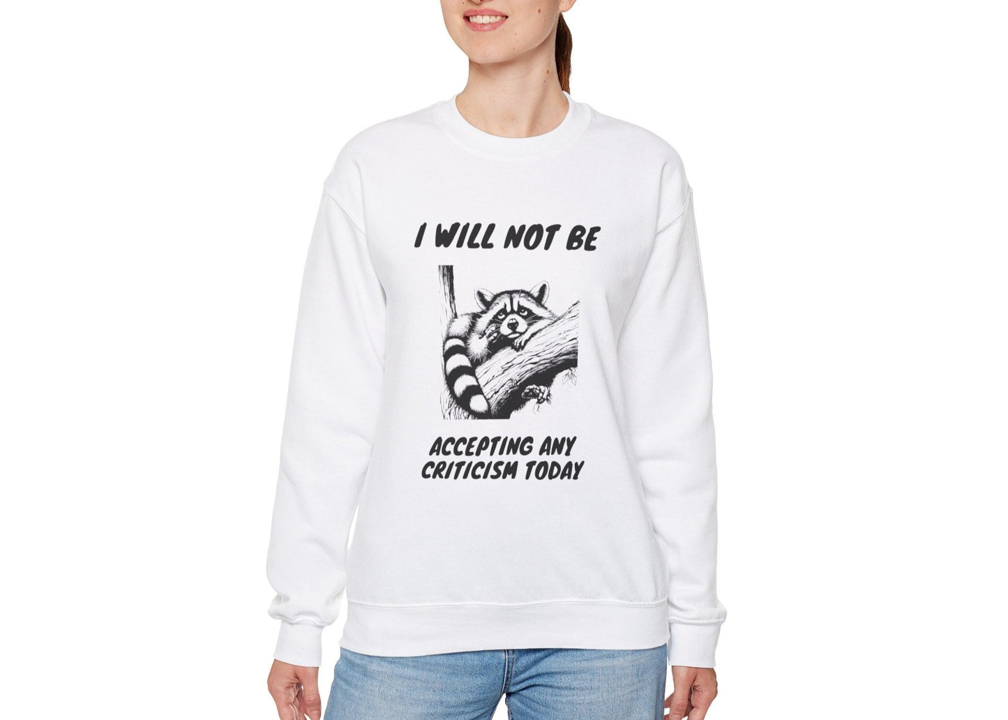 Model wearing a white sweater jumper with the text "I Will Not Be Accepting Any Criticism Today" and a cartoon illustration of a hand with a raised finger. Part of the Vivid Divergence Sensory Friendly Unisex Sweater Jumper Range.