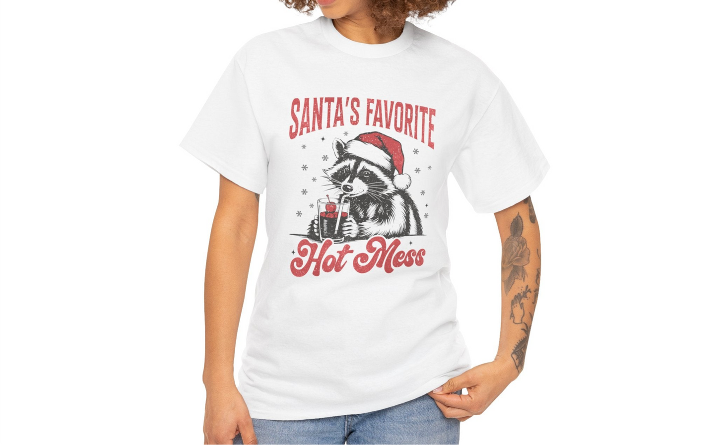Model wearing a white T-shirt featuring a "Santa's Favorite Hot Mess" design with a festive raccoon wearing a Santa hat. Part of the Vivid Divergence Sensory Friendly Unisex Tees Range.