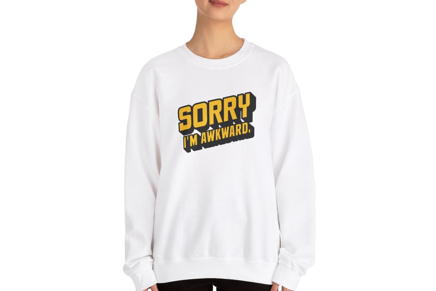 Model wearing a white sweater jumper with the text "Sorry, I'm Awkward." in bold yellow lettering. Part of the Vivid Divergence Sensory Friendly Unisex Sweater Jumper Range.