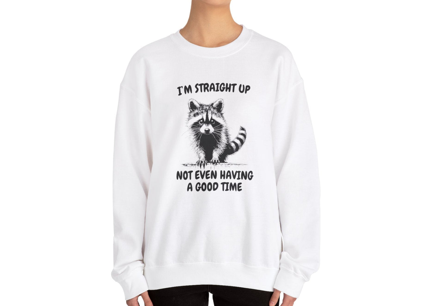 Model wearing a white sweater jumper with the text "I'm Straight Up Not Even Having a Good Time" and a cartoon raccoon illustration. Part of the Vivid Divergence Sensory Friendly Unisex Sweater Jumper Range.