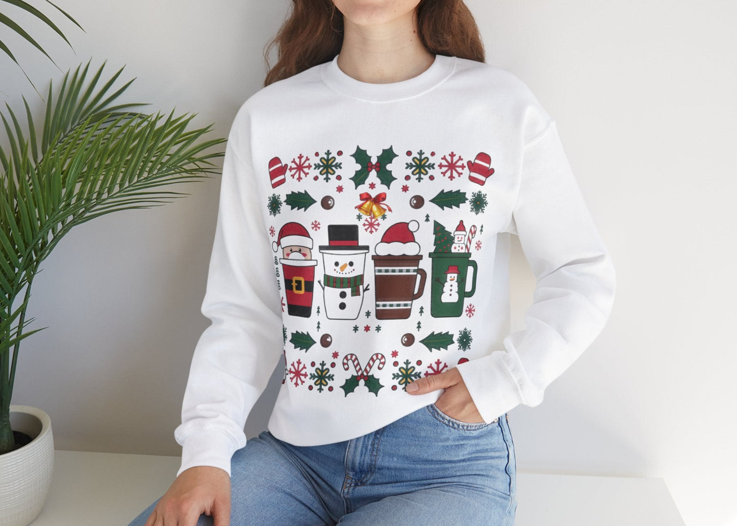 Model wearing a white sweatshirt featuring a festive holiday pattern with coffee cups, snowflakes, and Christmas elements, styled casually. Part of the Vivid Divergence Sensory Friendly Unisex Sweater Jumper Range.