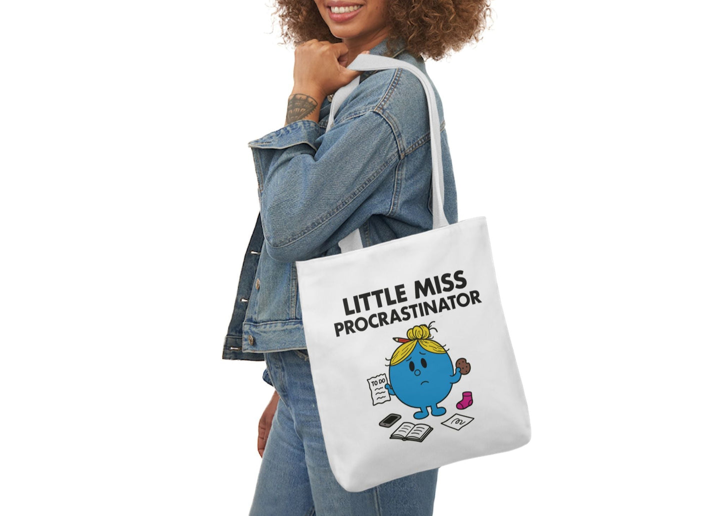 Woman in denim modeling the Little Miss Procrastinator tote bag over her shoulder. She hasn’t started the thing, but she did reorganize her desktop. Part of the Vivid Divergence Little Miss Meme Collection!
