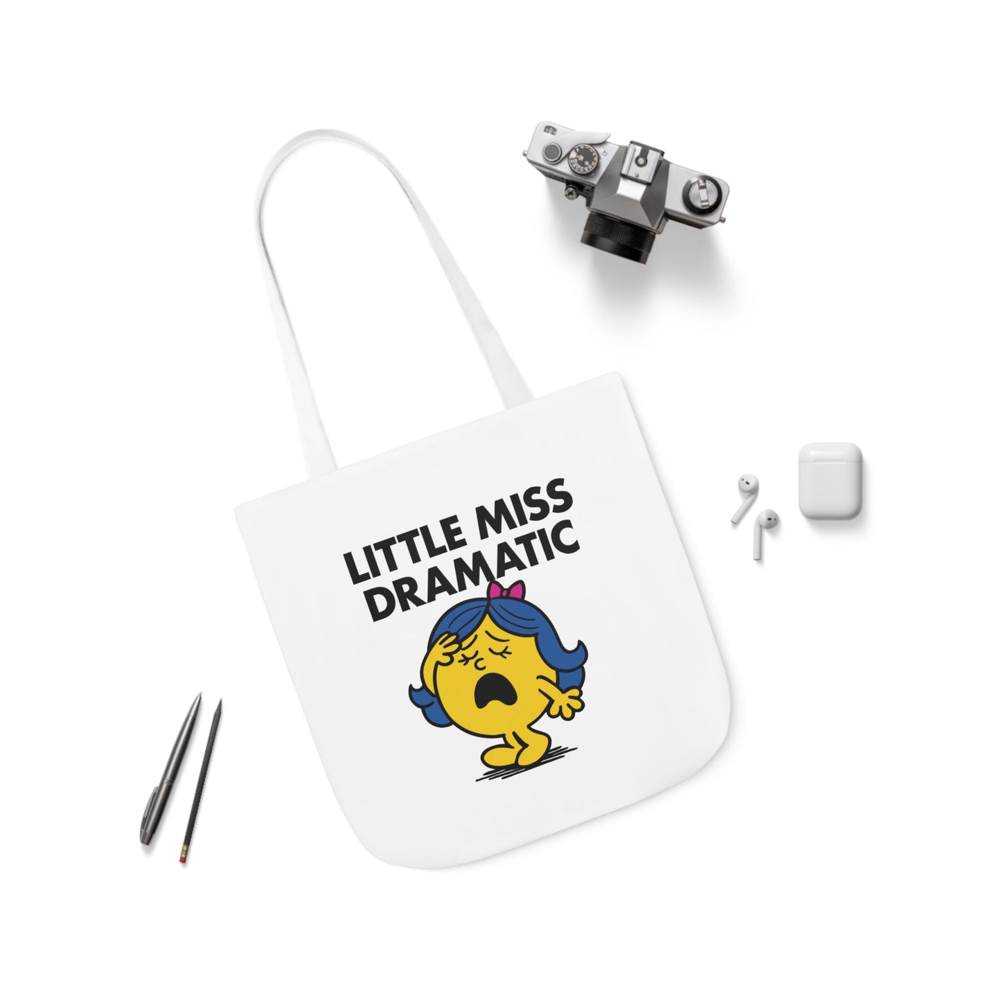 Flat lay of tote bag featuring Little Miss Dramatic surrounded by accessories. She just saw a text with “...” and is spiraling. Part of the Vivid Divergence Little Miss Meme Collection!
