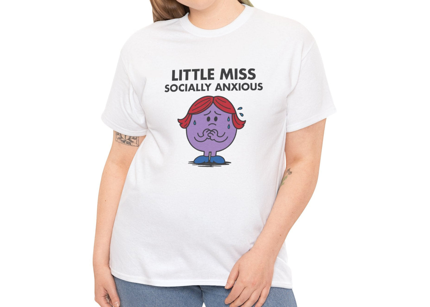 Person wearing the Little Miss Socially Anxious T-shirt with casual blue jeans. Part of the Little Miss Meme Character Collection. A Vivid Divergence Sensory Friendly Unisex Tee.
