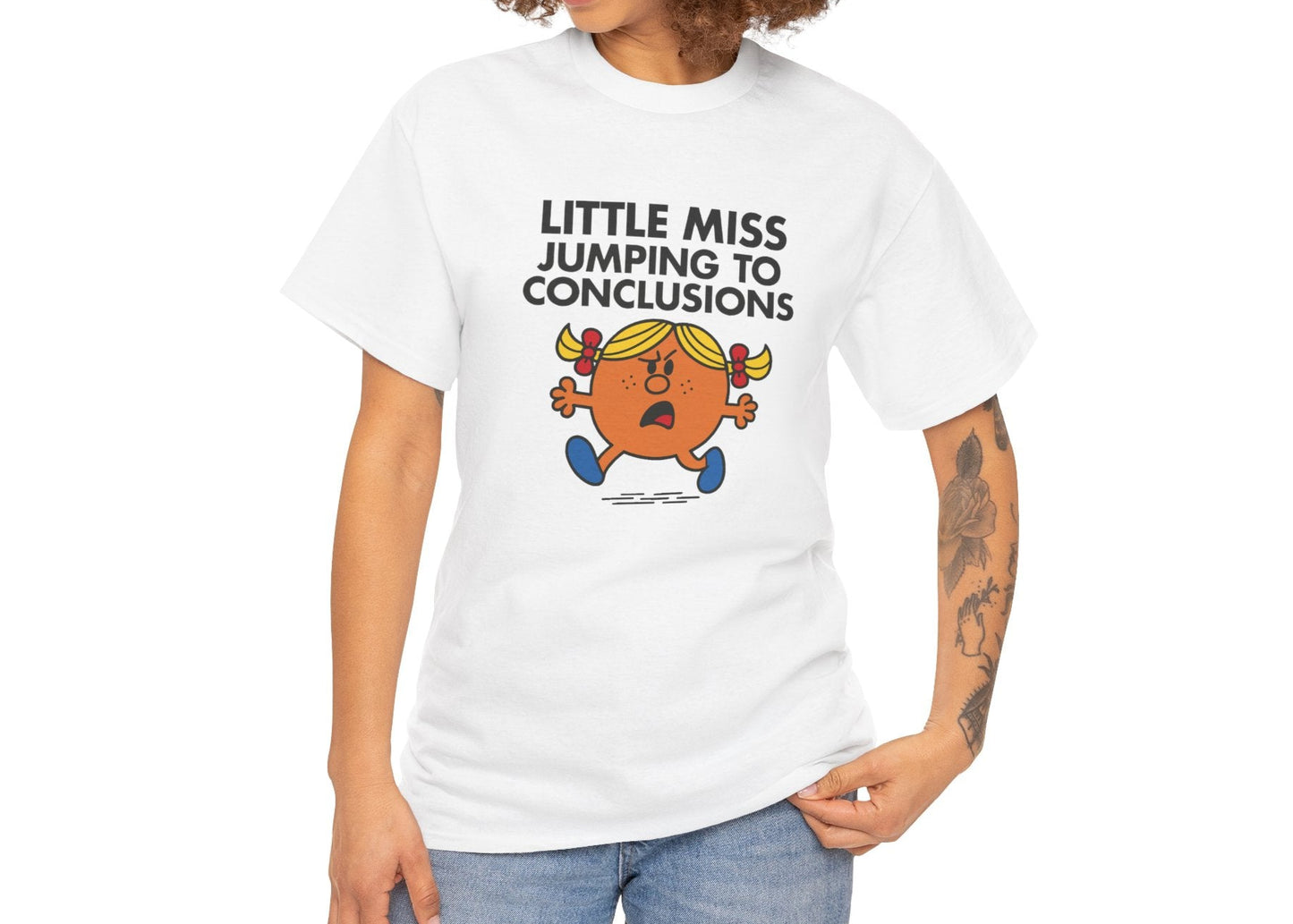 Person wearing the Little Miss Jumping To Conclusions T-shirt with jeans. Part of the Little Miss Meme Character Collection. A Vivid Divergence Sensory Friendly Unisex Tee.
