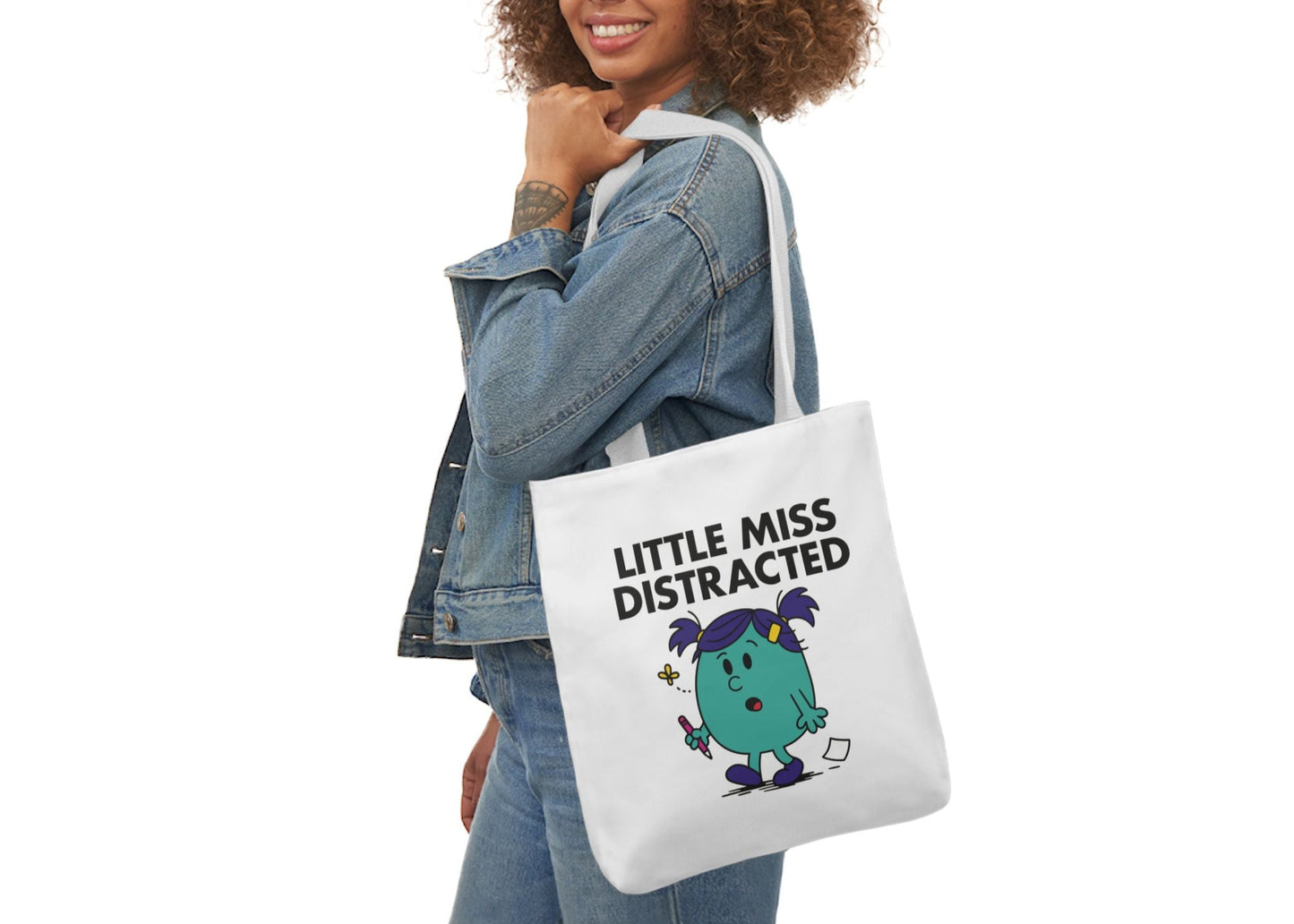 Woman in denim modeling the Little Miss Distracted tote bag on her shoulder. She walked into the room and forgot why. Part of the Vivid Divergence Little Miss Meme Collection!
