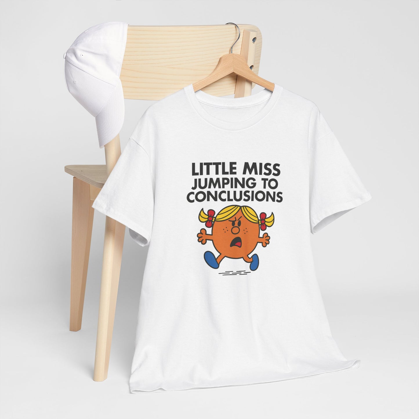 Little Miss Jumping To Conclusions T-shirt draped over a chair in a clean space. Part of the Little Miss Meme Character Collection. A Vivid Divergence Sensory Friendly Unisex Tee.
