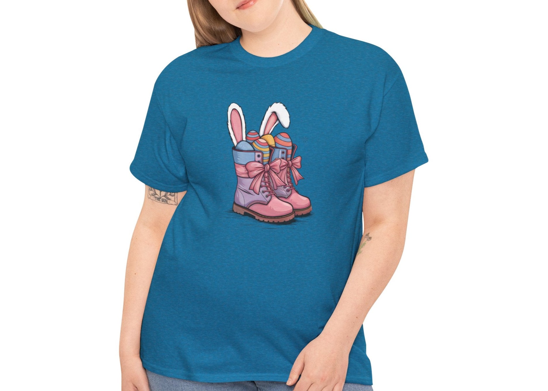 Woman wearing an Antique Sapphire Easter T-shirt featuring cowgirl boots with bunny ears and colorful eggs, a fun and festive holiday look. Hop into the season in style and shop Easter shirts online today!