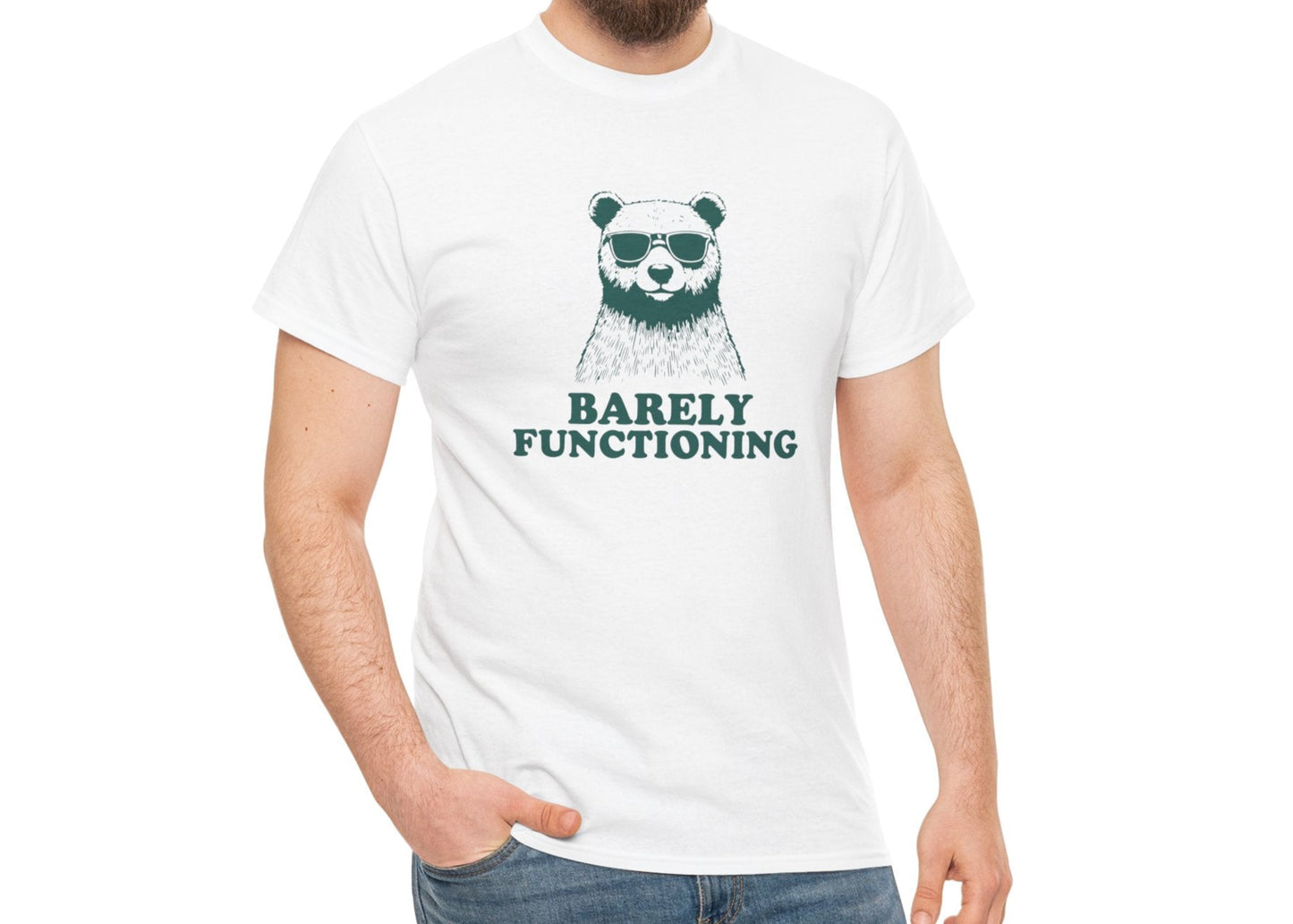 Male model wearing a white T-shirt with a green bear graphic and "Barely Functioning" text. Part of the Vivid Divergence Sensory Friendly Unisex Tees Range.