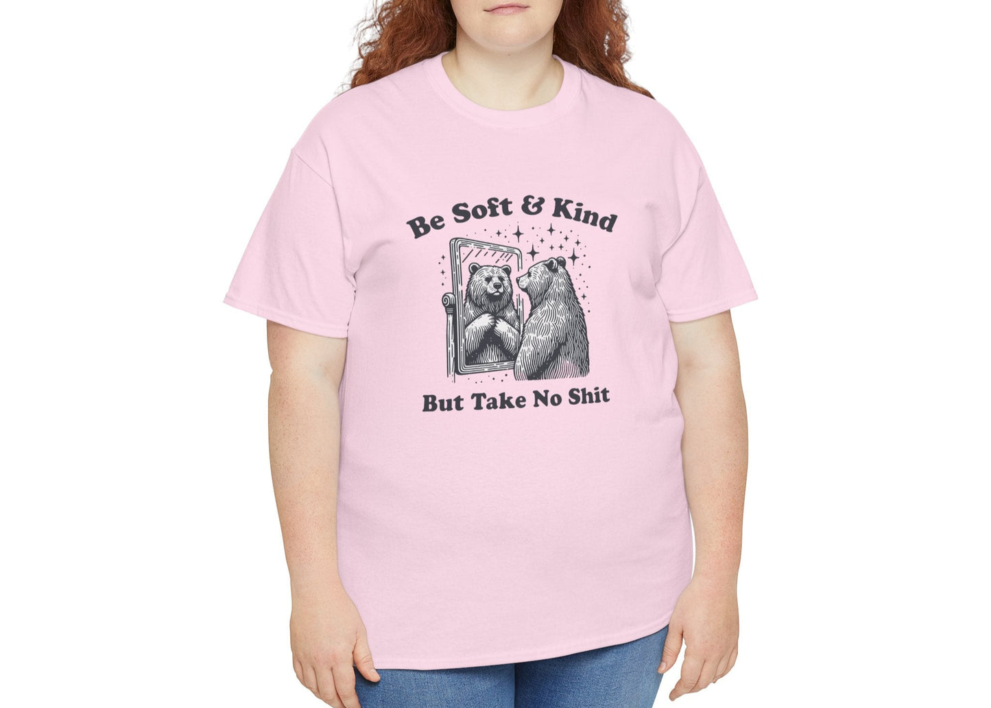 Woman in pink T-shirt with empowering bear graphic. Smiling through the chaos, but won’t tolerate nonsense. Part of the Vivid Divergence Memewear Collection!
