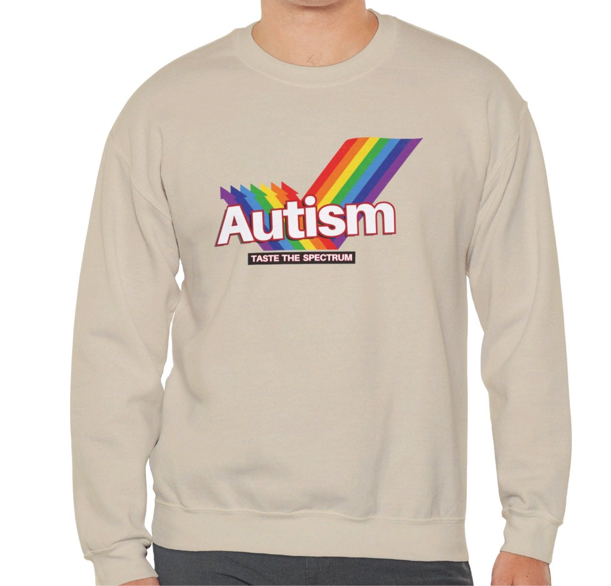 Model wearing a beige sweater jumper with an "Autism" Skittles brand parody design featuring rainbow stripes. Part of the Vivid Divergence Sensory Friendly Unisex Sweater Jumper Range.