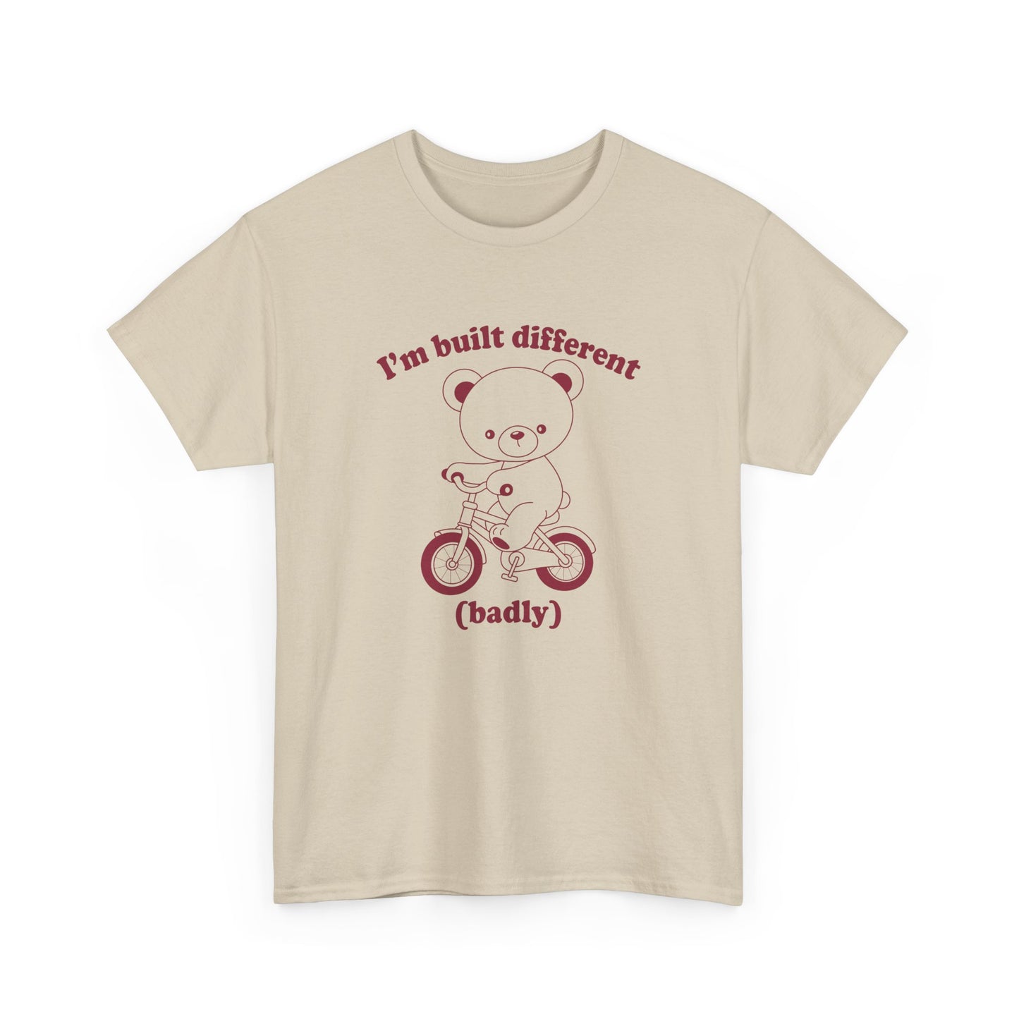 Front view of a beige T-shirt featuring the "Built Different (Badly)" bear design. Part of the Vivid Divergence Sensory Friendly Unisex Tees Range.