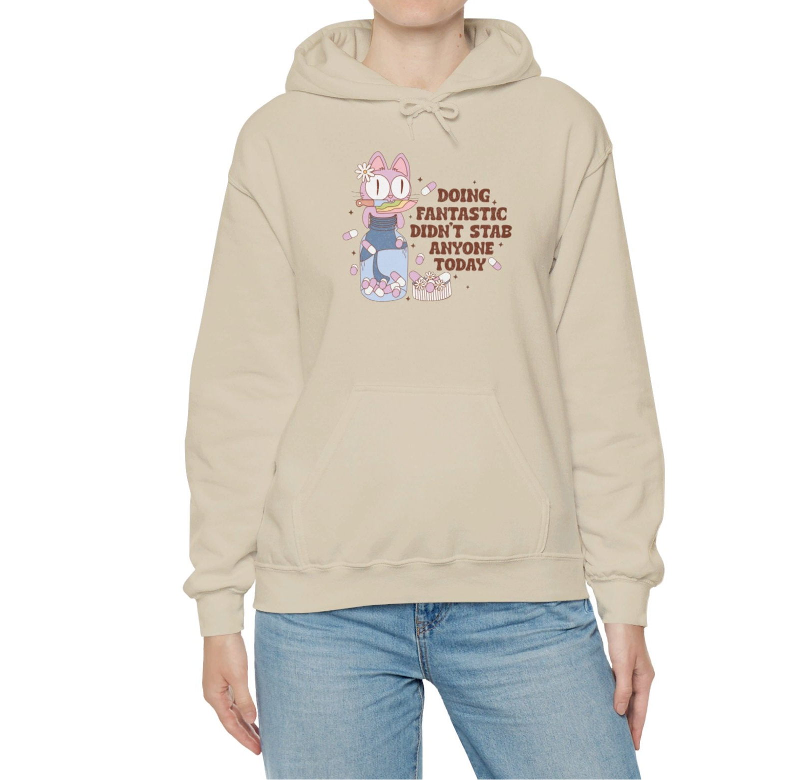 Model wearing a beige hoodie featuring the text "Doing Fantastic, Didn’t Stab Anyone Today" and a cartoon illustration of a raccoon holding a knife. Part of the Vivid Divergence Sensory Friendly Unisex Hoodie Range.