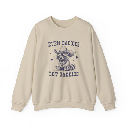 Front view of a beige sweater jumper with the text "Even Baddies Get Saddies" and a cartoon raccoon illustration. Part of the Vivid Divergence Sensory Friendly Unisex Sweater Jumper Range.