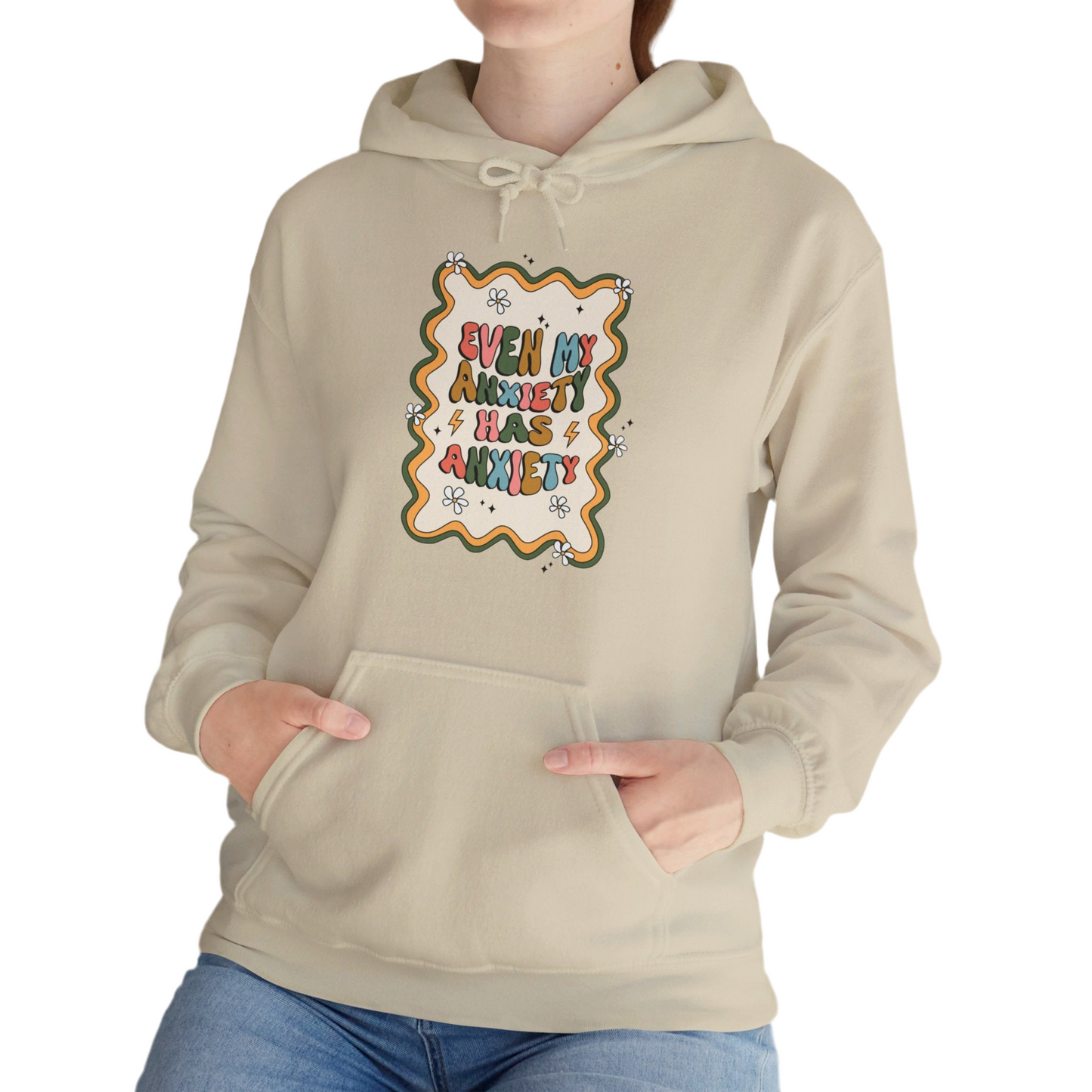 Model wearing a beige hoodie with the text "Even My Anxiety Has Anxiety" surrounded by a decorative frame design. Part of the Vivid Divergence Sensory Friendly Unisex Hoodie Range.