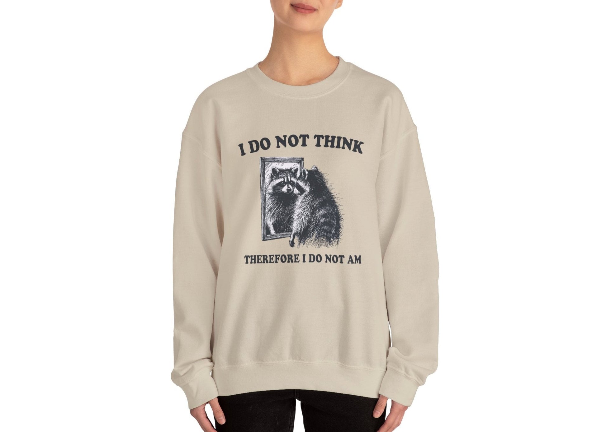 Model wearing a beige sweater jumper with the text "I Do Not Think, Therefore I Do Not Am" and a cartoon raccoon illustration. Part of the Vivid Divergence Sensory Friendly Unisex Sweater Jumper Range.