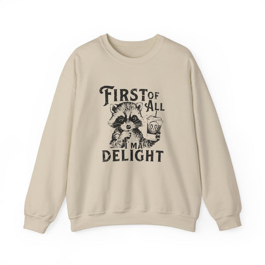 Front view of a beige sweater jumper with the text "First of All, I’m a Delight" and a cartoon raccoon illustration. Part of the Vivid Divergence Sensory Friendly Unisex Sweater Jumper Range.