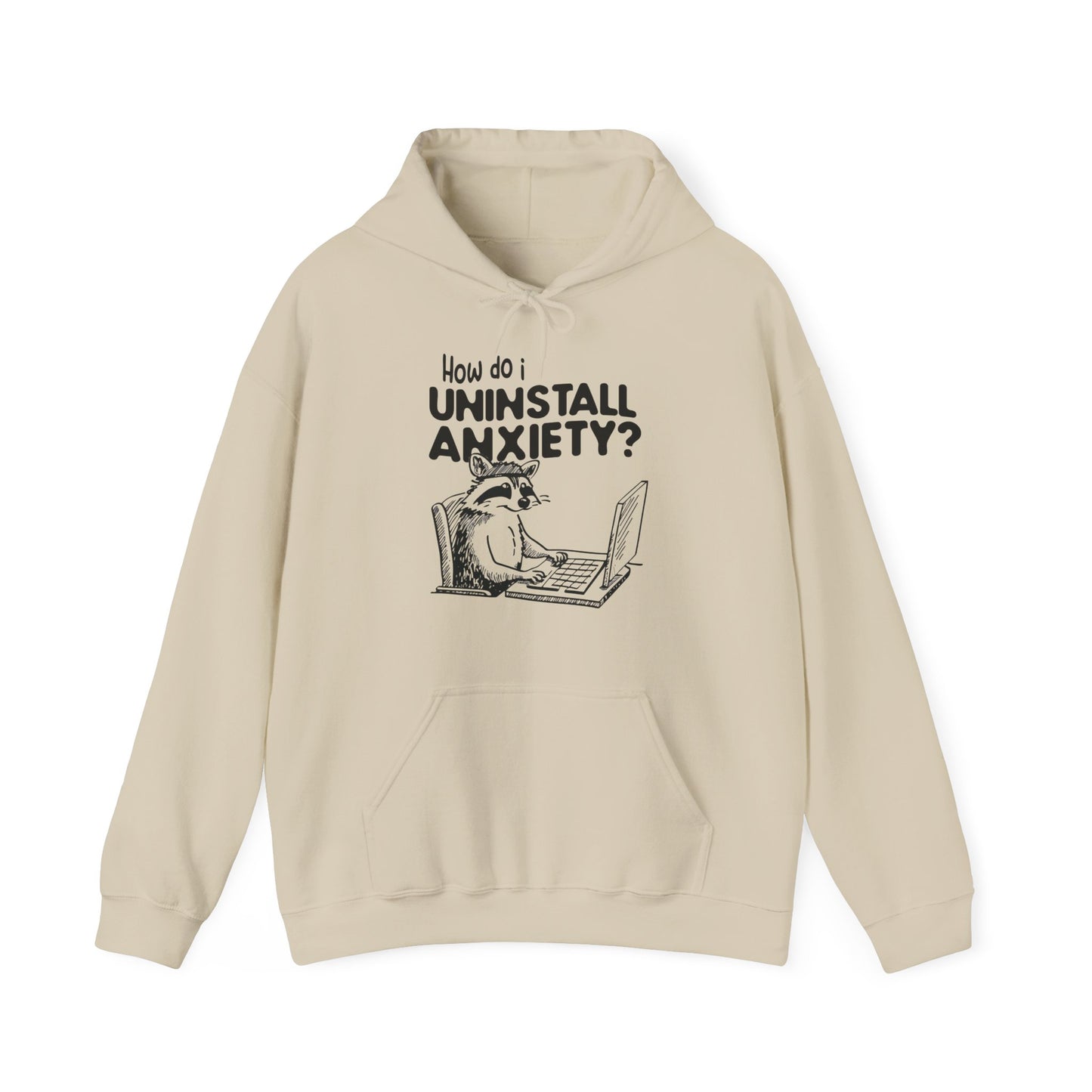 Front view of a beige hoodie featuring the text "How Do I Uninstall Anxiety?" and a cartoon illustration of a raccoon using a laptop. Part of the Vivid Divergence Sensory Friendly Unisex Hoodie Range.