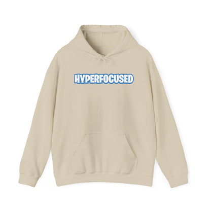 Front view of a beige hoodie featuring the word "HYPERFOCUSED" in a bold, blue Fortnite-style font. Part of the Vivid Divergence Sensory Friendly Unisex Hoodie Range.