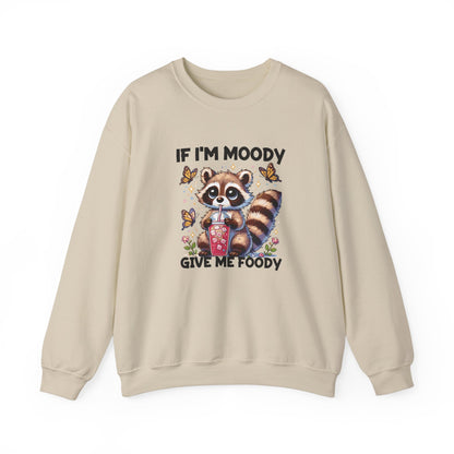 Front view of a beige sweater jumper with the text "If I'm Moody, Give Me Foody" and a cartoon raccoon illustration holding snacks. Part of the Vivid Divergence Sensory Friendly Unisex Sweater Jumper Range.