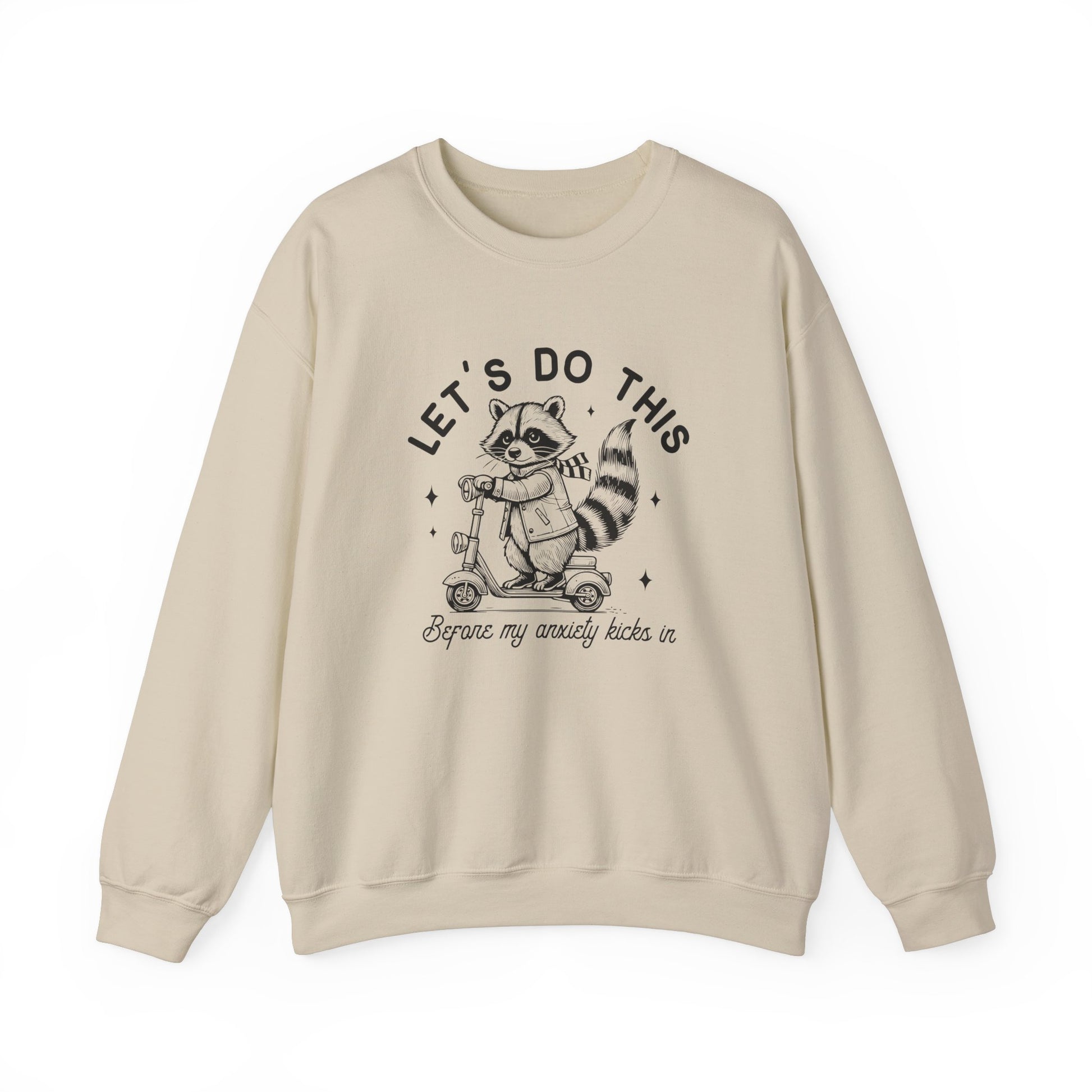 Front view of a beige sweatshirt featuring a cartoon raccoon riding a scooter with the text "Let's Do This Before My Anxiety Kicks In." Part of the Vivid Divergence Sensory Friendly Unisex Sweater Jumper Range.