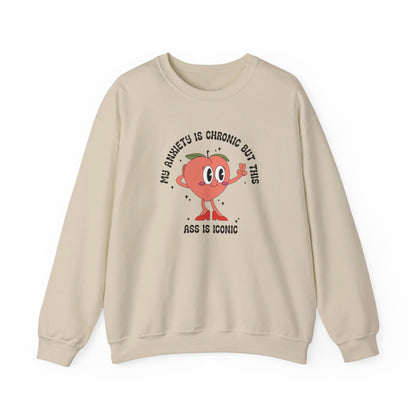 Front view of a beige sweater jumper with the text "My anxiety is chronic but this ass is iconic" and a cartoon peach illustration. Part of the Vivid Divergence Sensory Friendly Unisex Sweater Jumper Range.