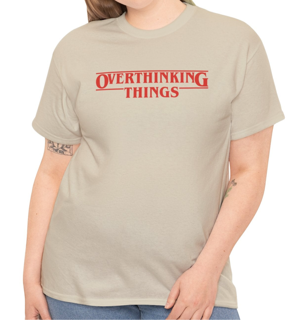 Model wearing a beige T-shirt with "Overthinking Things" in red text, parodying Stranger Things. Part of the Vivid Divergence Sensory Friendly Unisex Tees Range.