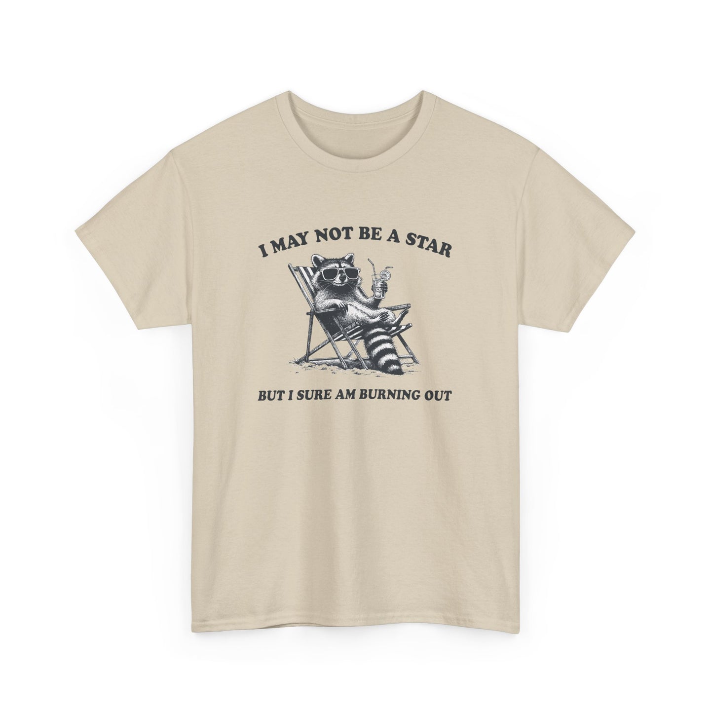 Hanging front view of a beige T-shirt featuring a cute raccoon holding a star with text that reads "I May Not Be A Star, But I Sure Am Burning Out." Part of the Vivid Divergence Sensory Friendly Unisex Tees Range.