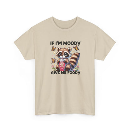Front view of a beige T-shirt featuring a raccoon graphic with food and the text "If I'm Moody, Give Me Foody." Part of the Vivid Divergence Sensory Friendly Unisex Tees Range.