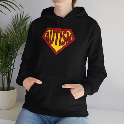 Model wearing a black hoodie featuring the text "Autism" inside a Superman-style red and yellow shield design. Part of the Vivid Divergence Sensory Friendly Unisex Hoodie Range.