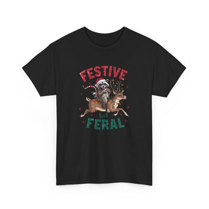 Front view of a black T-shirt featuring a festive illustration of a raccoon (trash panda) holding Christmas lights and the text "Festive but Feral." Part of the Vivid Divergence Sensory Friendly Unisex Tees Range.