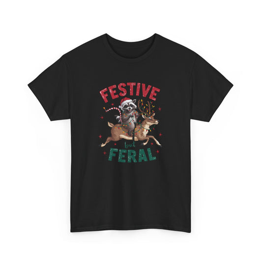 Front view of a black T-shirt featuring a festive illustration of a raccoon (trash panda) holding Christmas lights and the text "Festive but Feral." Part of the Vivid Divergence Sensory Friendly Unisex Tees Range.