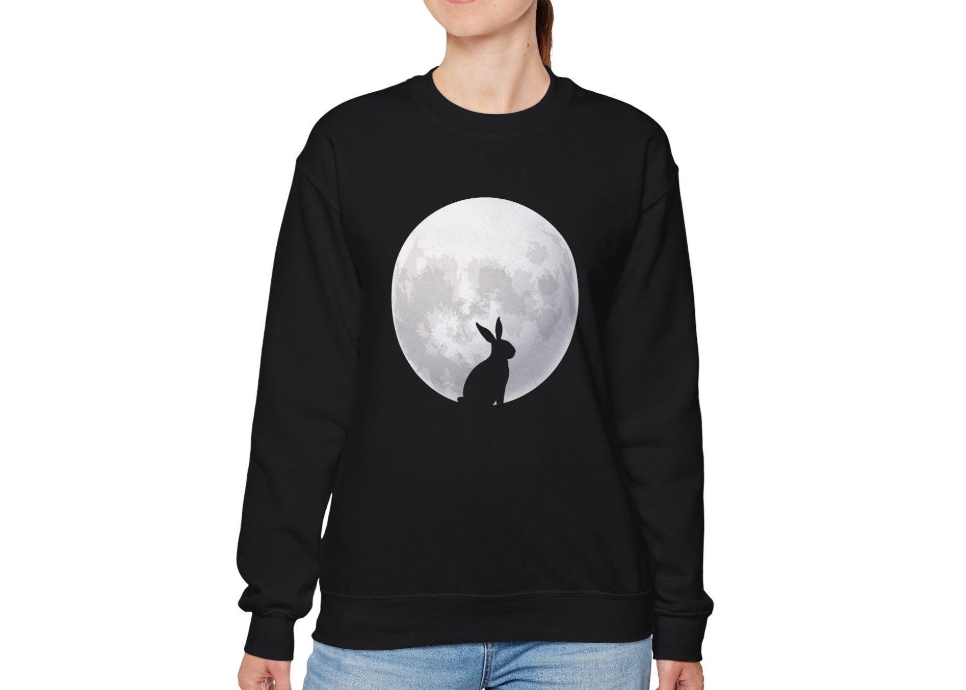 Woman wearing black sweater jumper with full moon and Easter bunny silhouette. Part of the Vivid Divergence Sensory Friendly Unisex Sweater Jumper Range.

