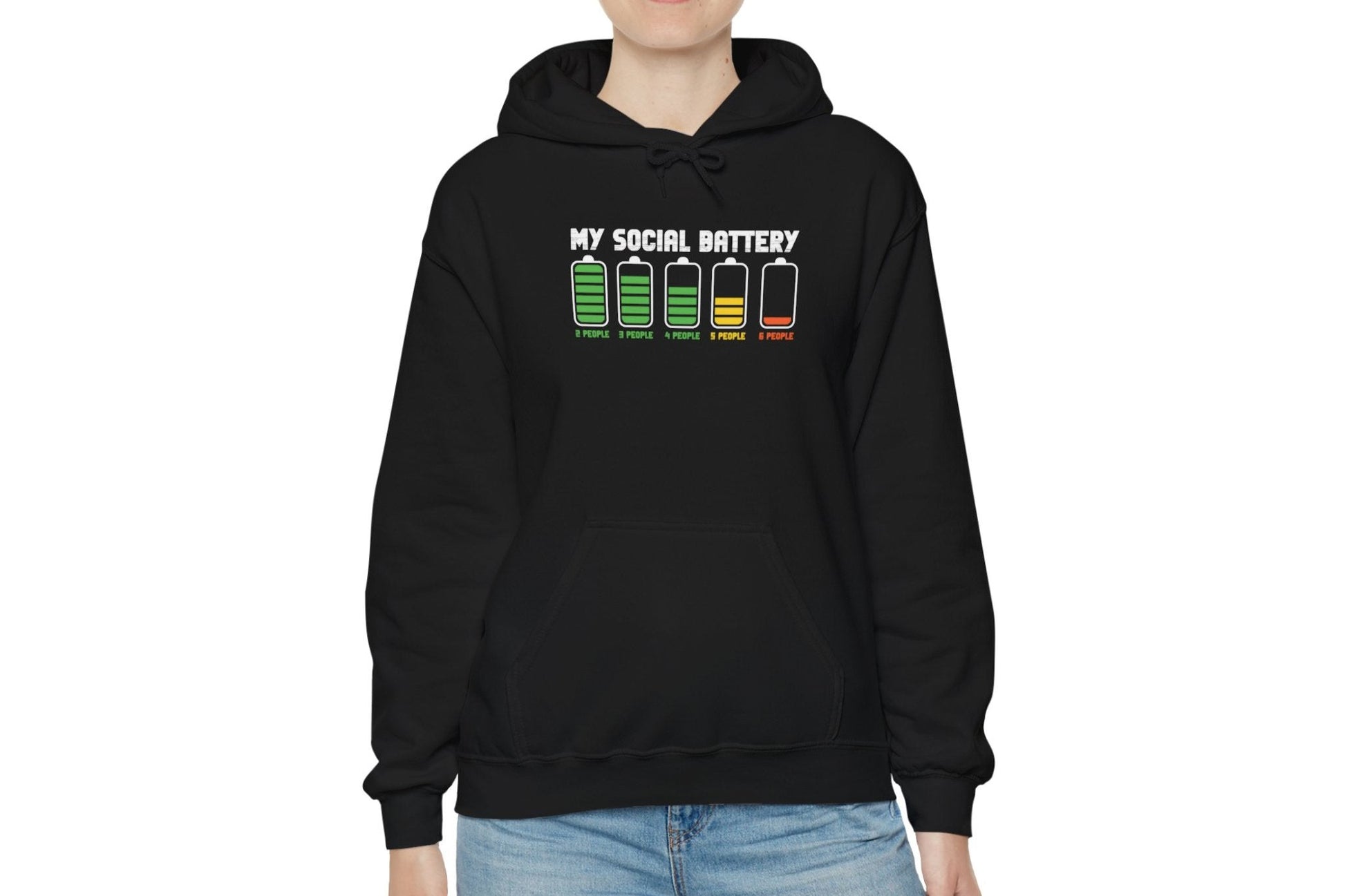Model wearing a black hoodie featuring the text "My Social Battery" with a series of battery icons decreasing from full to empty. Part of the Vivid Divergence Sensory Friendly Unisex Hoodie Range.
