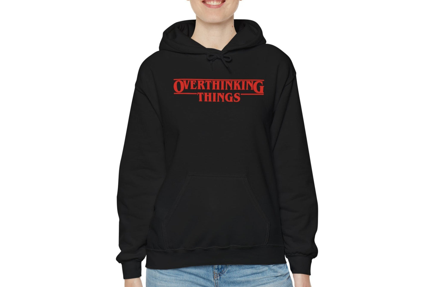 Model wearing a black hoodie featuring the text "Overthinking Things" in the iconic Stranger Things font and style. Part of the Vivid Divergence Sensory Friendly Unisex Hoodie Range.
