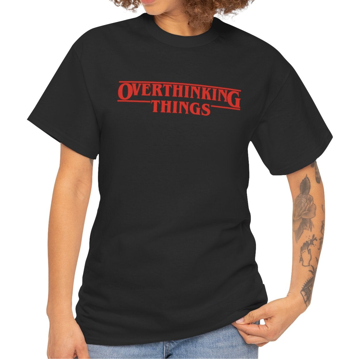 Model wearing a black T-shirt with "Overthinking Things" in red text, parodying Stranger Things. Part of the Vivid Divergence Sensory Friendly Unisex Tees Range.