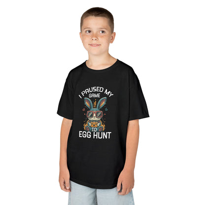 Child wearing a black Easter T-shirt with "I Paused My Game to Egg Hunt" and a gaming-style bunny, a fun and festive look for young gamers. Hop into the season in style and shop Easter shirts online today!