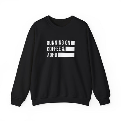 Front view of a black sweater jumper with the text "Running on Coffee & ADHD" in bold white lettering and a battery graphic. Part of the Vivid Divergence Sensory Friendly Unisex Sweater Jumper Range.