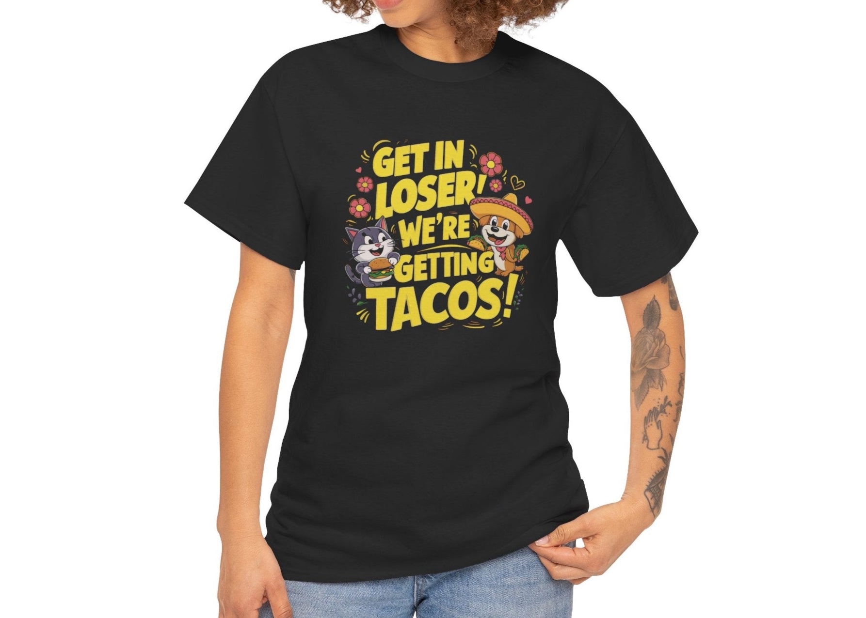 Modeled front view of a black T-shirt with colorful text and illustrations of cute animals in a car that reads "Get In Loser, We're Getting Tacos!" Part of the Vivid Divergence Sensory Friendly Unisex Tees Range.