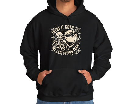 Model wearing a black hoodie featuring the text "There It Goes, My Last Flying F*ck" with a cartoon illustration of a flying bird holding a banner. Part of the Vivid Divergence Sensory Friendly Unisex Hoodie Range.