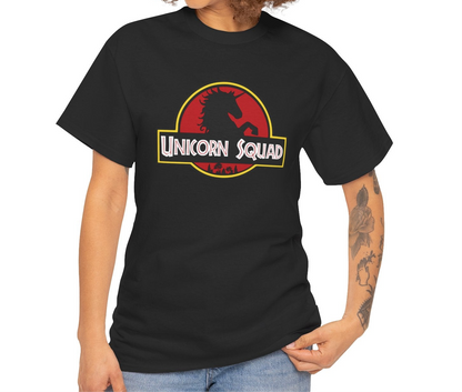 Model standing near a window wearing a black T-shirt with "Unicorn Squad" in bold white text inside a red and yellow Jurassic Park-style logo featuring a unicorn silhouette. Part of the Vivid Divergence Sensory Friendly Unisex Tees Range.