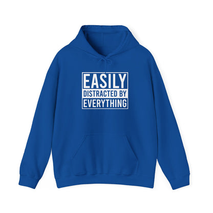 Front view of a blue hoodie with the text "Easily Distracted by Everything" in bold white lettering. Part of the Vivid Divergence Sensory Friendly Unisex Hoodie Range.
