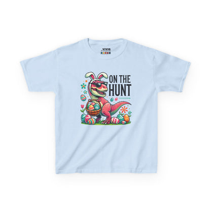 Light blue kids' T-shirt featuring a fun Easter dinosaur with "On the Hunt" text, surrounded by eggs and festive decorations. Hop into the season in style and shop Easter shirts online today!